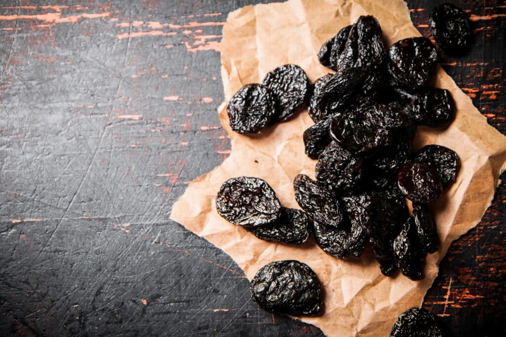 Prunes on paper on the table.